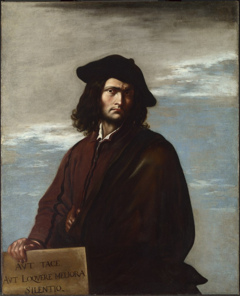 A bust-length painted portrait of a white man with a dark beard and long dark hair dressed in a dark brown cloak holding a sign in one hand. 