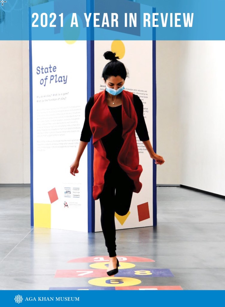 A document cover that reads 2021 A Year in Review, with a picture of a young woman participating in an exhibition activity at the Aga Khan Museum.