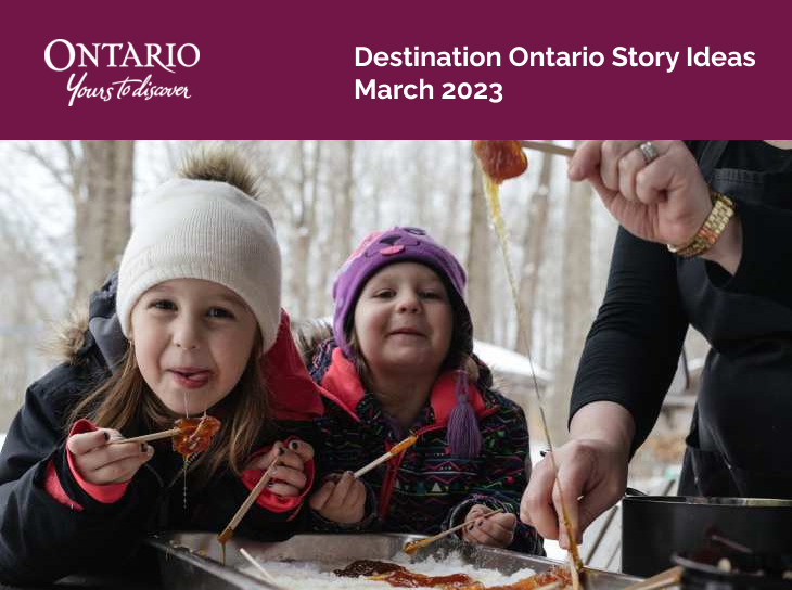 Two young girls eating maple syrup outdoors.